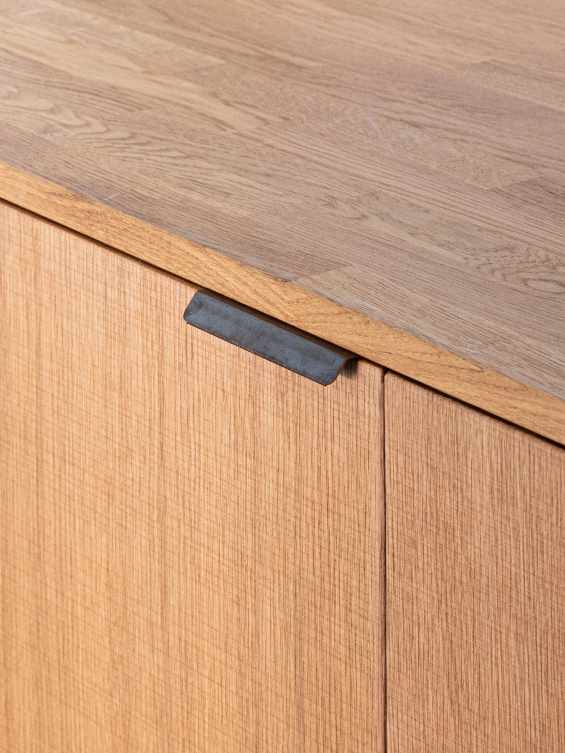 Handle in burnished copper on front in natural oak